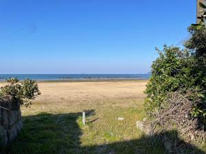 an empty field with the ocean in the background at 音毬 - Otomari - in Miyazu