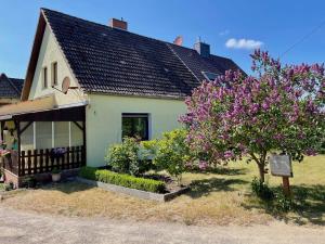 a house with a flowering tree in front of it at Ferienhaus "Am Flachsee" in Sophienhof
