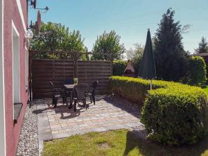 a patio with a table and chairs and an umbrella at Ferienwohnungen am Bach in Marlow