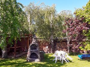 a garden with two chairs and a stone fireplace at Ferienwohnungen am Bach in Marlow
