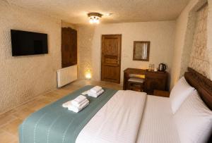 a bedroom with a bed with towels on it at Kayaharman cave otel in Nar