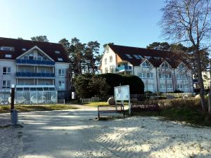 two benches sitting in front of a building at Blaumuschel Haus A Wohnung 2 - DH in Lubmin