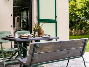 a wooden bench sitting in front of a table at Ferienwohnung im Spöckerhus in Tribohm