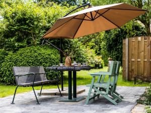 a table and two chairs and an umbrella on a patio at Ferienwohnung im Spöckerhus in Tribohm