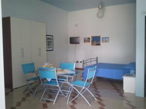 a dining room with a blue table and chairs at Terra di Fuori in Patù