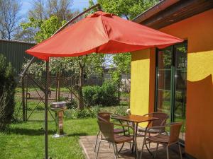 a table and chairs with a red umbrella on a patio at Ferienhaus Bohne in Rubitz
