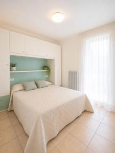 una camera da letto con un grande letto e una finestra di Residence Solemar - Agenzia Cocal a Caorle