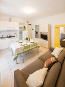un soggiorno e una cucina con divano e tavolo di Residence Solemar - Agenzia Cocal a Caorle