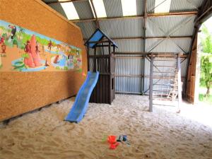 a play room with a slide in the sand at Ferienwohnung Galerie 1 in Hakendorferwurp