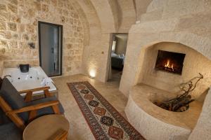 a living room with a fireplace and a bath tub at Kayaharman cave otel in Nar