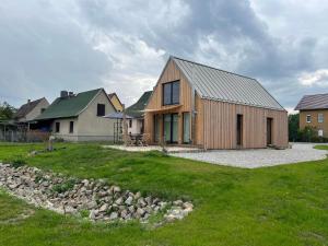 a wooden house in a yard next to a house at Gribertshaus in Klein Uhyst