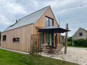 a wooden house with a table and an umbrella at Gribertshaus in Klein Uhyst