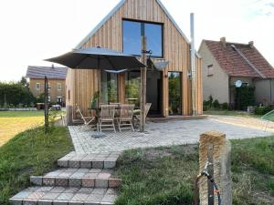 a house with an umbrella and a table and chairs at Gribertshaus in Klein Uhyst +55 photos