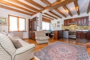 a living room with two couches and a kitchen at Ciase Ai Ronch in Falcade