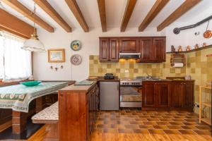 a kitchen with wooden cabinets and a counter top at Ciase Ai Ronch in Falcade +17 photos
