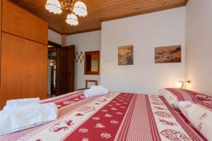 a bedroom with two beds with red and white blankets at Ciase Ai Ronch in Falcade