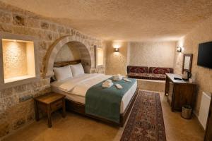 a bedroom with a large bed in a stone room at Kayaharman cave otel in Nar
