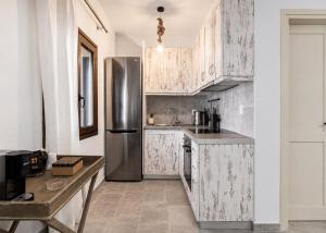 a kitchen with wooden cabinets and a stainless steel refrigerator at Marilia ViIlage Spathi Kea "Studio The Goat" in Spathi 