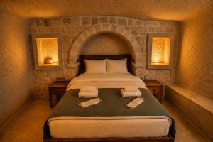 a bedroom with a bed with two towels on it at Kayaharman cave otel in Nar +40 photos
