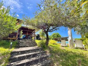 a set of stairs leading up to a house with a tree at Case Christal in Saint-Louis +4 photos