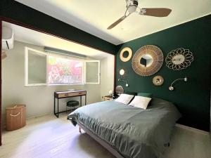 a bedroom with a green wall with a bed and a desk at Case Christal in Saint-Louis