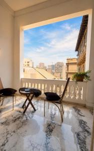 a balcony with two chairs and a large window at pal ace talaat harb in Cairo
