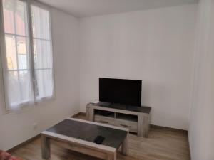 a living room with a flat screen tv on a table at Jauxvial 2 in Jaux