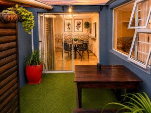 a screened in porch with a table and a dining room at Royal Palms Guest House in Port Elizabeth