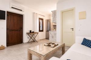a living room with a white couch and a coffee table at Marilia ViIlage Spathi Kea "Studio The Goat" in Spathi  +9 photos