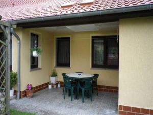a patio with a table and chairs on a house at Ferienwohnung "Ganz 1" in Vipperow