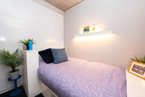 a small bedroom with a bed with purple sheets at Stephen's Quarter - Aparto in Dublin