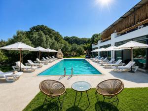 a swimming pool with chairs and umbrellas next to a building at Alya Hill Bodrum in Bodrum City