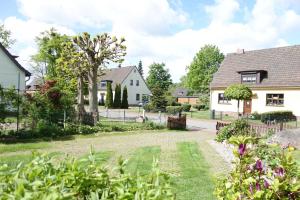 a house with a garden and a driveway at Ferienwohnung "Baum" in Rechlin