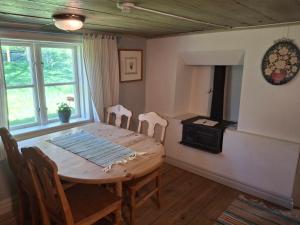 a dining room with a table and chairs and a stove at Mjölby Vandrarhem in Mjölby +64 photos