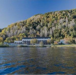 a large building on the shore of a body of water at Oppheim apartment, shared Pool & Sauna in Vossevangen