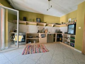 a kitchen with shelves and a television in a room at Good Hostel Prishtina in Prishtinë +17 photos