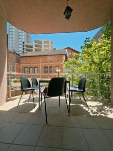 a patio with three chairs and a table on a balcony at Good Hostel Prishtina in Prishtinë
