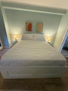 a large white bed in a room with two lamps at Superiore 33 room apartment in Pignone +13 photos