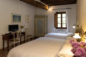 a bedroom with two beds and a desk with a computer at L'Arcadia in Pietrasanta