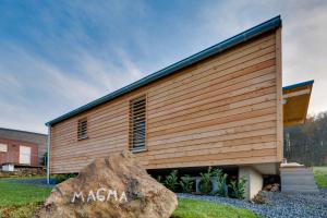a wooden building with a large rock in front of it at Ferienhaus Eifeltraum Magma in Berlingen