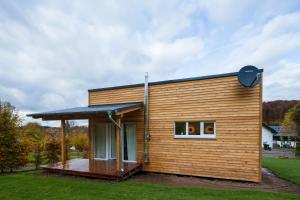 a small wooden house with a deck at Ferienhaus Eifeltraum Magma in Berlingen