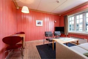a living room with red walls and a table and chairs at Hafjell apartment, Ilsetra in Øyer