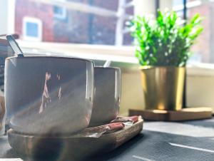 two cups sitting on a table with a potted plant at The Marlowe in Southport