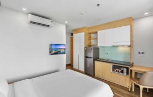 a small bedroom with a bed and a kitchen at Seasol Beach Boutique hotel in Danang