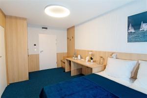 a hotel room with a bed and a desk at Marina Apartamenty ChKŻ in Charzykowy
