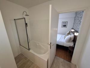 a bathroom with a walk in shower next to a bed at Les Cols Verts - Logis Hôtels in La Tranche-sur-Mer +51 photos