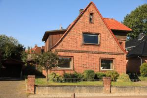 a brick house with a fence in front of it at Ferienwohnung im Auenland in Bad Bramstedt