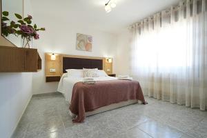 a bedroom with a bed with a table and a window at GALIHOST - Villa García in Valga +35 photos
