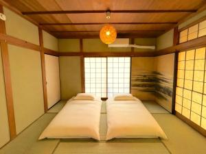 a row of beds in a room with a chandelier at 平城空間 - Heijo Space in Nara