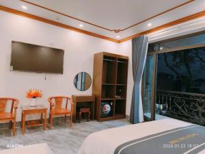 a bedroom with a tv and a table and chairs at Tam Coc Cozy Hotel in Vũ Lâm